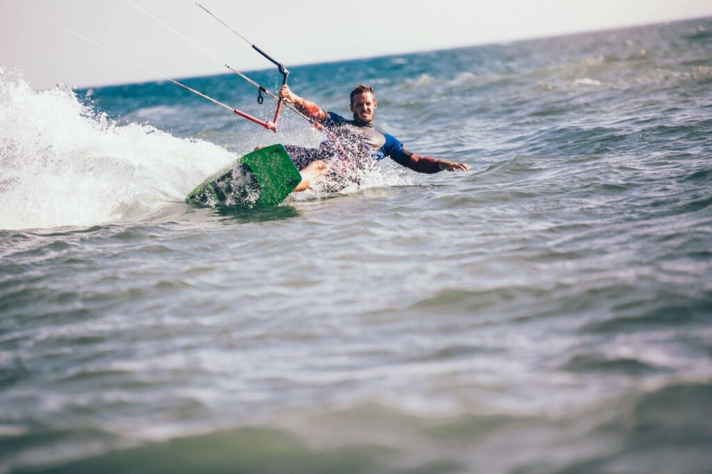 Un kitesurfer navighează pe valuri, folosind un echipament robust