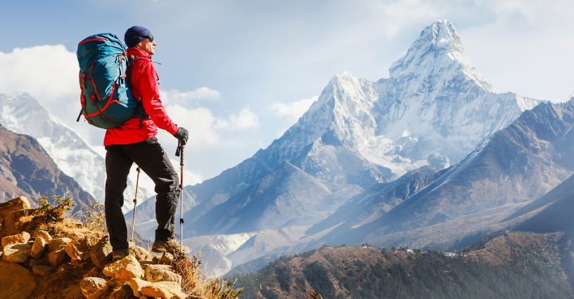 Persoană echipată pentru drumeție admiră peisajul montan