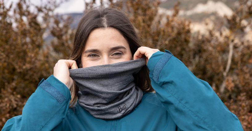 Persoană poartă un buff gri pentru protecție în aer liber